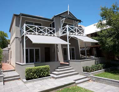 Grey folding arm awnings on the exterior of a two storey house in Perth