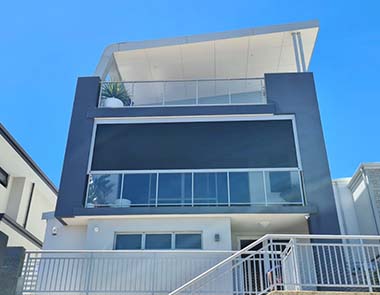 Multistorey house with dark ziptraks over balcony form Kenlow