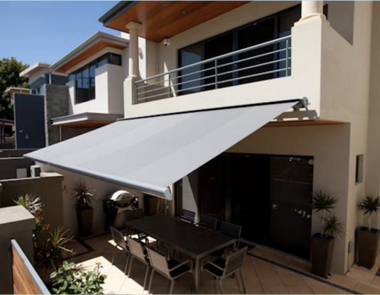 Grey folding arm awning on beige two storey house in Perth from Kenlow