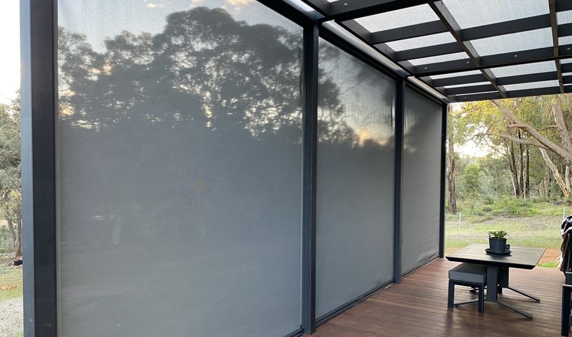 Outdoor decking area focused on the black, vertical ziptrak blinds