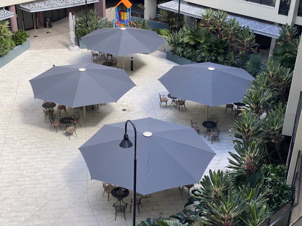 Four ultrashade heavy duty umbrellas providing shade to a open courtyard