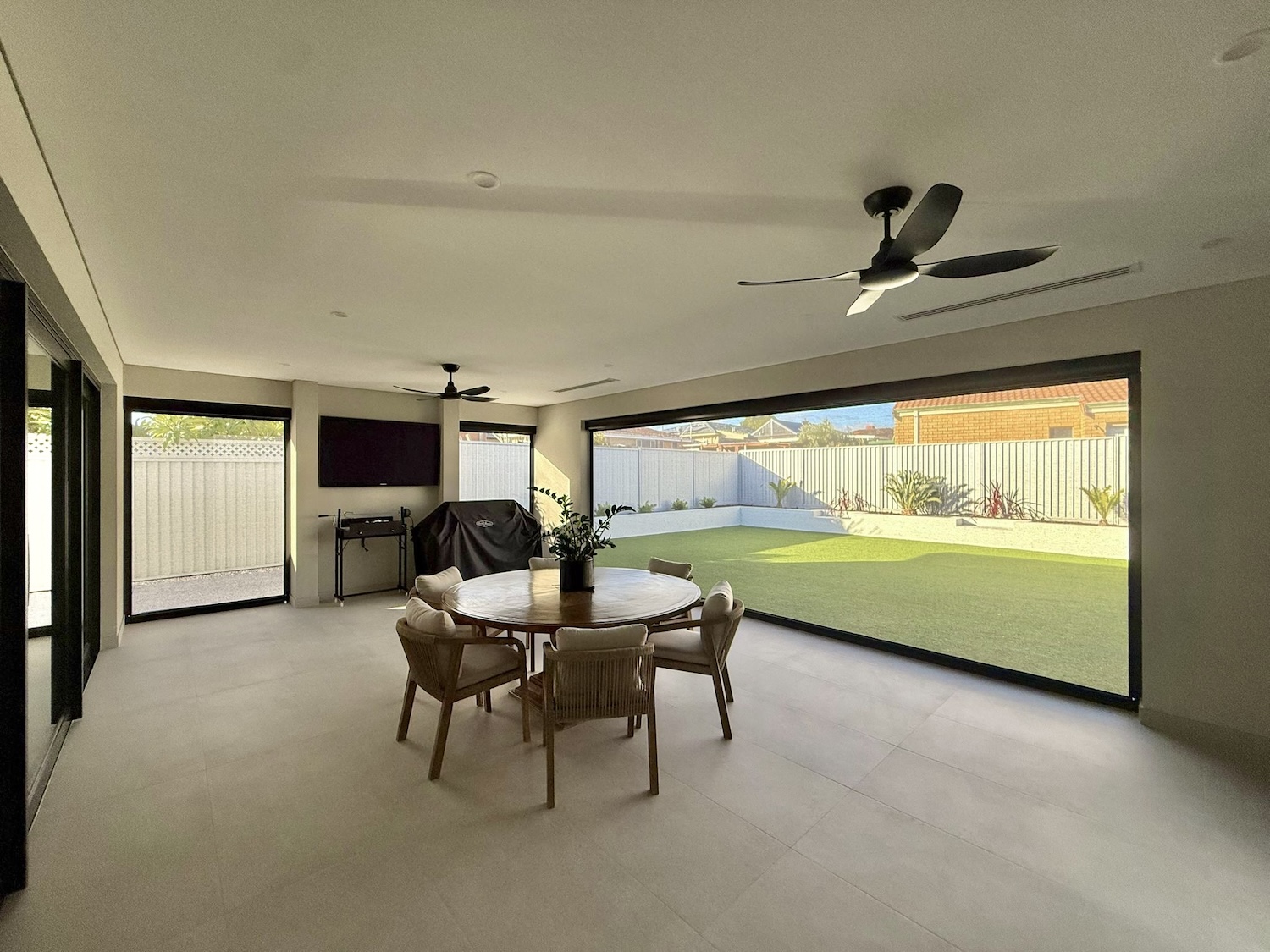 Alfresco living and dining space with mesh blinds opening up to the backyard