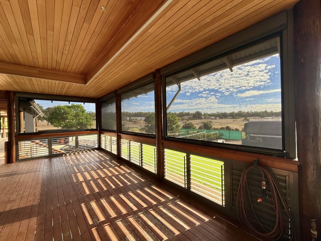 Mesh blinds fitted along a timber verandah with views