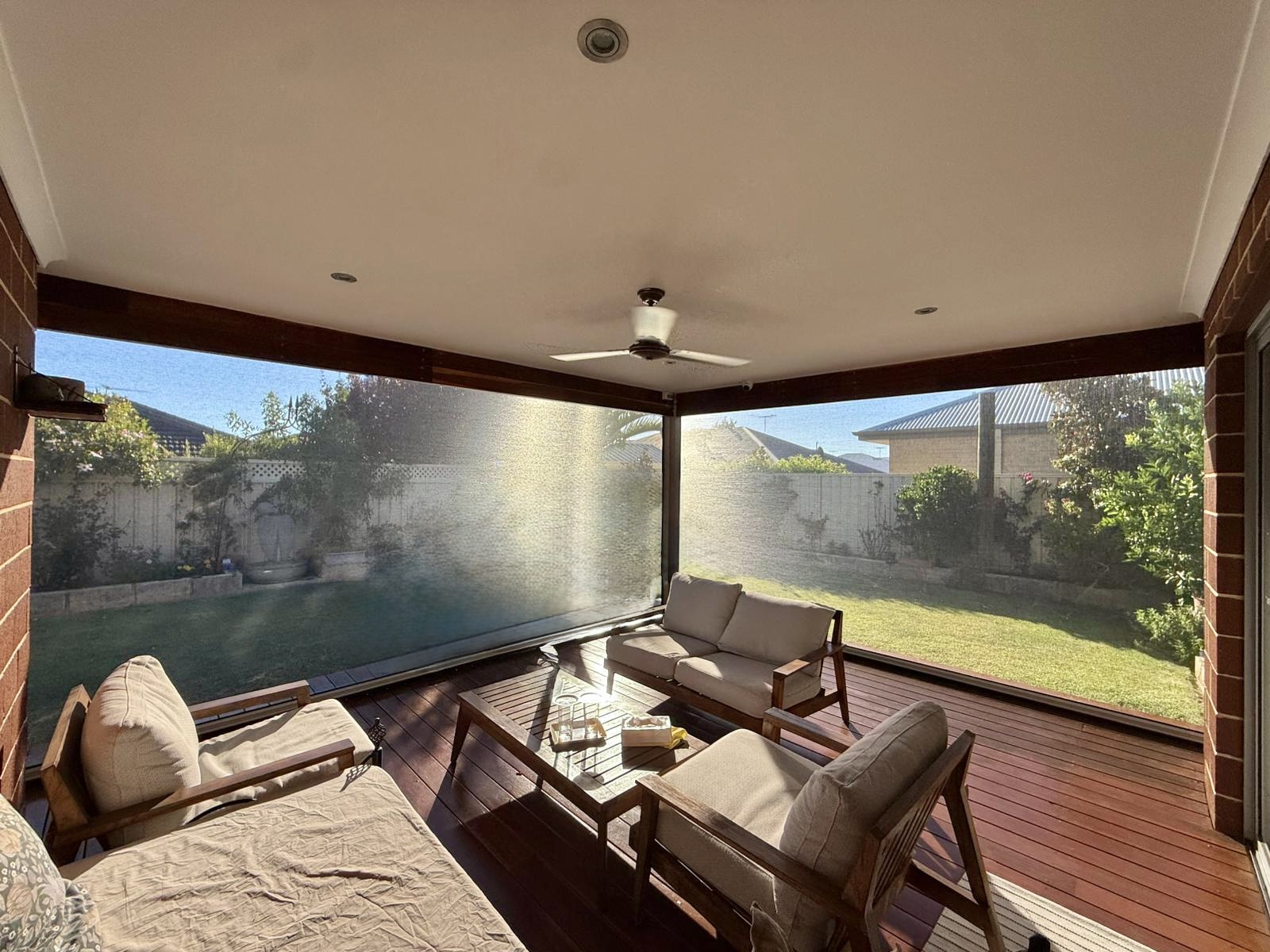 Mesh patio blind Perth enclosing an alfresco with outdoor lounge furniture